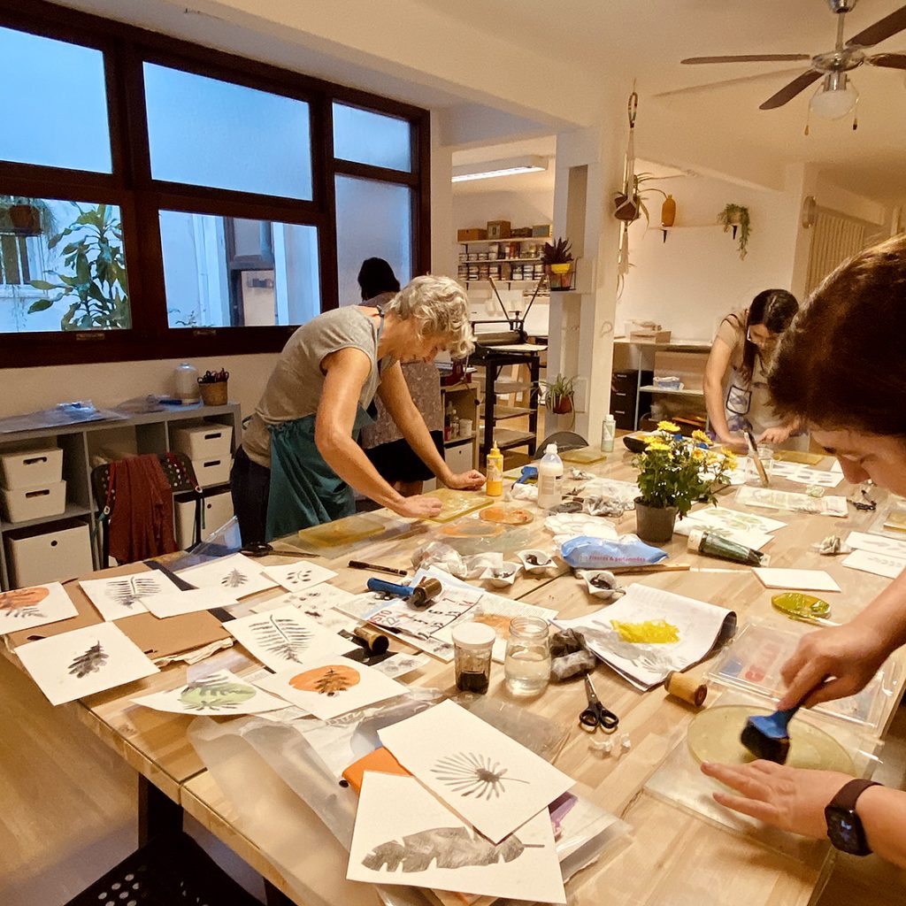 Mujeres realizando taller creativo con técnica mixta y de estampación de plantas en papel